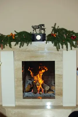 a fireplace with a clock on top of it at Villa Cheval in Aukštadvaris