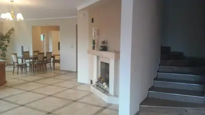 a living room with a fireplace and a staircase at Villa Cheval in Aukštadvaris