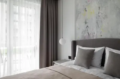 a bedroom with a bed with a large window at No. 1 PARK AVENUE APARTMENT in Kaunas