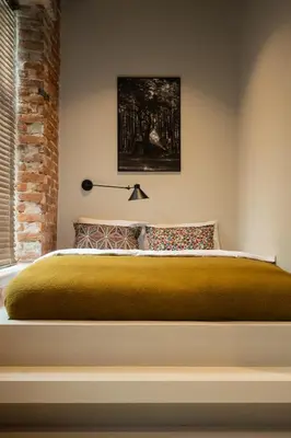 a bedroom with a large bed with a brick wall at Hortus Vilnius in Vilnius