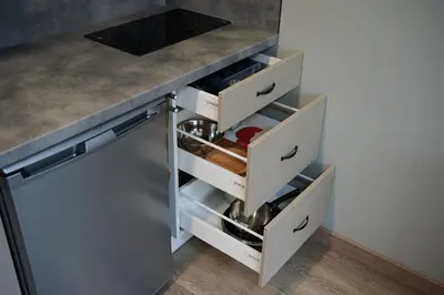a kitchen with white drawers and a counter at Studio COZY VISIT, balcony, 24h self check-in, first floor, great location in Kaunas