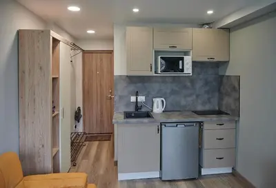 a kitchen with white cabinets and a counter top at Studio COZY VISIT, balcony, 24h self check-in, first floor, great location in Kaunas