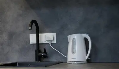 a kitchen counter with a sink with a water faucet at Studio COZY VISIT, balcony, 24h self check-in, first floor, great location in Kaunas