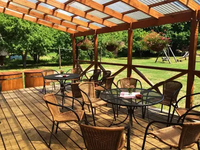 a patio with tables and chairs under a wooden pergola at Sodyba Duburiai in Ukmergė