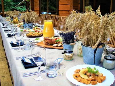 a long table with plates of food and wine glasses at Sodyba Duburiai in Ukmergė