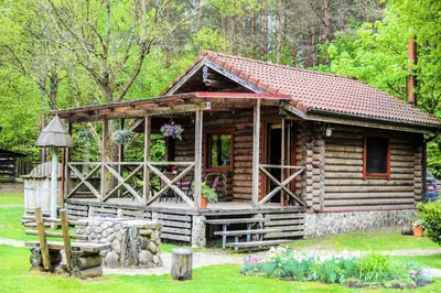 a log cabin with a porch and a window at Sodyba Duburiai in Ukmergė