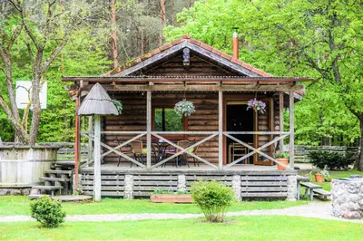 a log cabin in a yard with a porch at Sodyba Duburiai in Ukmergė