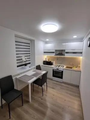 a kitchen and dining room with a table and chairs at Trumpalaike buto nuoma in Rokiškis