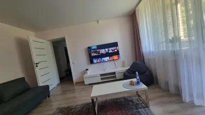 a living room with a couch and a tv at Trumpalaike buto nuoma in Rokiškis