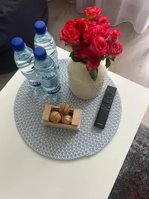 a table with a vase of roses and a box of almonds at Trumpalaike buto nuoma in Rokiškis