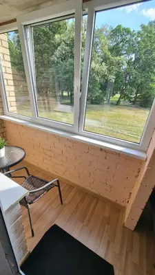 a room with two windows and a table and a chair at Trumpalaike buto nuoma in Rokiškis
