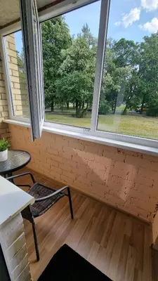 a room with two windows and a table and a chair at Trumpalaike buto nuoma in Rokiškis