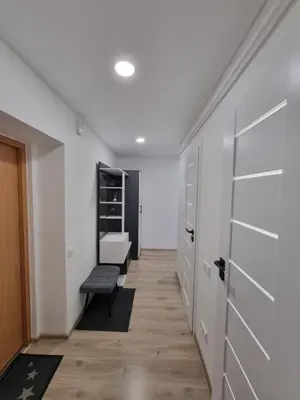 a hallway with white walls and a door and a bench at Trumpalaike buto nuoma in Rokiškis
