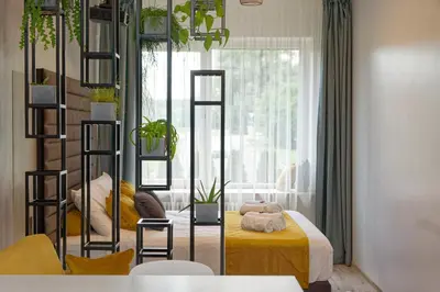 a room with a bedroom with a bed and a window at Munu Holiday Apartments in Druskininkai