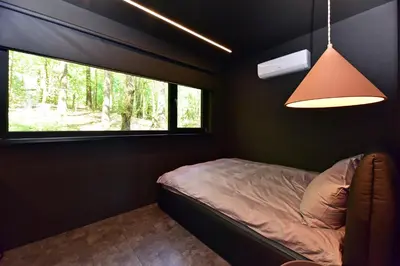 a small bedroom with a bed and a window at Premium Forest Bungalow With Hot Tub & Sauna in Luokesos Sen