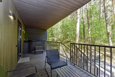 a screened porch with a chair on a deck at Premium Forest Bungalow With Hot Tub & Sauna in Luokesos Sen