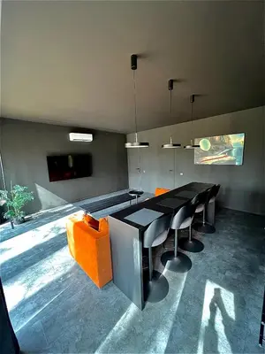 a dining room with a black table and orange chairs at Premium Forest Bungalow With Hot Tub & Sauna in Luokesos Sen