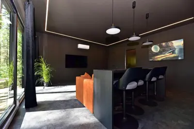 an office with a bar with black chairs and a couch at Premium Forest Bungalow With Hot Tub & Sauna in Luokesos Sen
