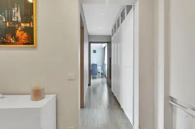 a hallway with white walls and wood floors and a painting at Tower View Apartment in Vilnius