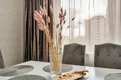 a vase with flowers in it sitting on a table at Tower View Apartment in Vilnius