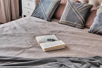 a book sitting on top of a bed at Tower View Apartment in Vilnius