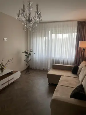 a living room with a couch and a chandelier at Comfort home Šiauliai in Šiauliai