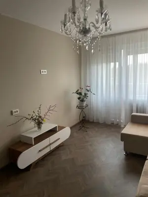 a living room with a chandelier and a couch at Comfort home Šiauliai in Šiauliai