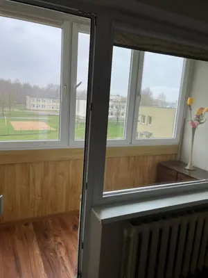 a room with three windows with a view of a field at Comfort home Šiauliai in Šiauliai