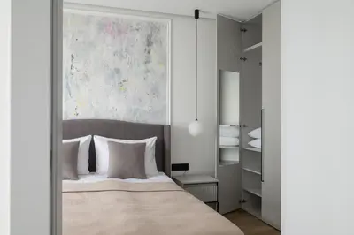 a bedroom with a bed and a painting on the wall at No. 2 PARK AVENUE APARTMENT in Kaunas