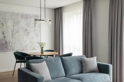 a living room with a blue couch and a table at No. 2 PARK AVENUE APARTMENT in Kaunas