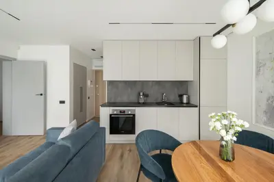 a kitchen and living room with a table and chairs at No. 2 PARK AVENUE APARTMENT in Kaunas