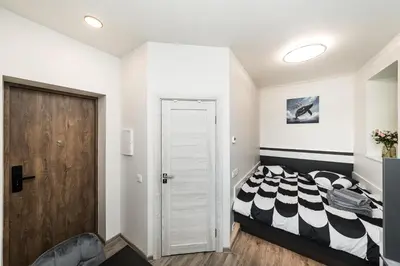 a bedroom with a black and white bed and a door at Riverra House in Kaunas