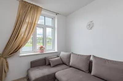 a living room with a couch and a window at Serene Nemunas River View apartment near McDonald by Polo Apartments in Kaunas