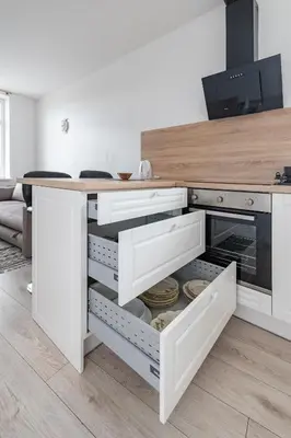 a kitchen with a counter with white drawers at Serene Nemunas River View apartment near McDonald by Polo Apartments in Kaunas