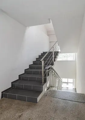 a staircase in a white room with black steps at Serene Nemunas River View apartment near McDonald by Polo Apartments in Kaunas