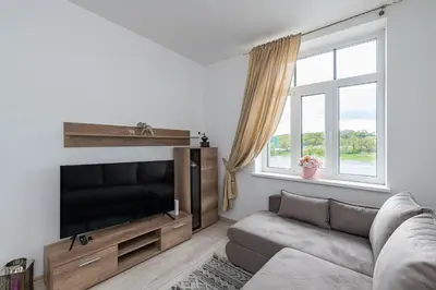 a living room with a couch and a flat screen tv at Serene Nemunas River View apartment near McDonald by Polo Apartments in Kaunas