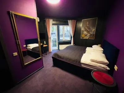 a purple bedroom with a bed and a mirror at Broken bed hootel in Kaunas