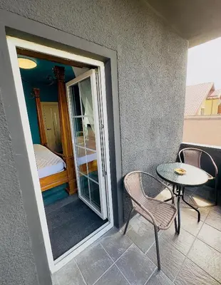a balcony with a table and chairs and a bedroom at Broken bed hootel in Kaunas