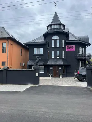 a black building with a tower on top of it at Broken bed hootel in Kaunas