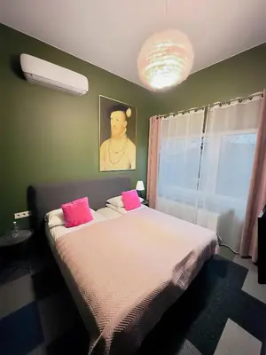 a bedroom with a large bed with pink pillows at Broken bed hootel in Kaunas