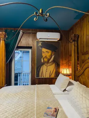 a bedroom with a painting of a man with a beard at Broken bed hootel in Kaunas