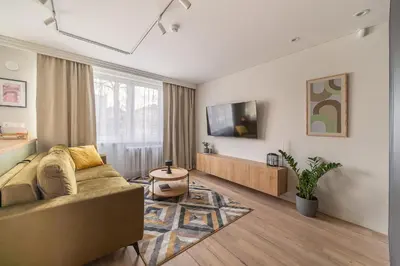 a living room with a couch and a tv at Lake Apartment in Šiauliai