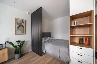 a bedroom with a bed and a book shelf at Lake Apartment in Šiauliai