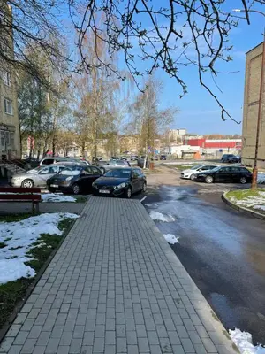 a parking lot with cars parked on a snowy street at Lake Apartment in Šiauliai
