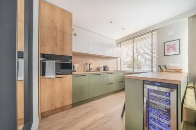 a kitchen with stainless steel appliances and wooden cabinets at Lake Apartment in Šiauliai
