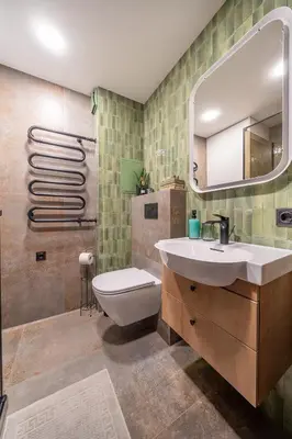 a bathroom with a sink and a toilet and a mirror at Lake Apartment in Šiauliai