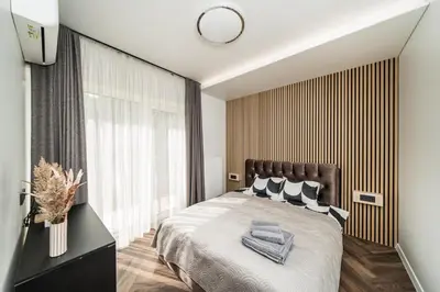 a bedroom with a bed and a large window at Riverra House - Panorama View Apartment in Kaunas