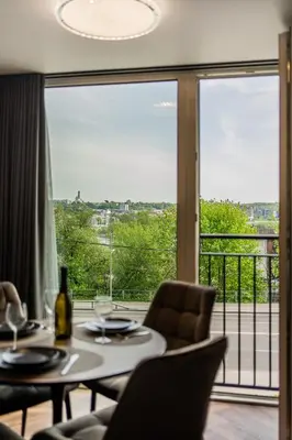 a room with a table and chairs and a large window at Riverra House - Panorama View Apartment in Kaunas