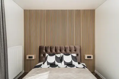 a bedroom with a bed with a brown headboard at Riverra House - Panorama View Apartment in Kaunas