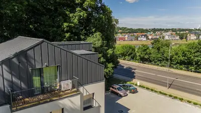 a building with a balcony next to a street at Riverra House - Panorama View Apartment in Kaunas